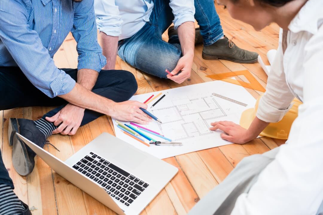 group of people working on a floor plan